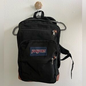 JanSport black backpack. Includes 2 large compartment, 3 smaller & drink holder.